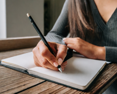 Woman writing in journal. The page is still empty